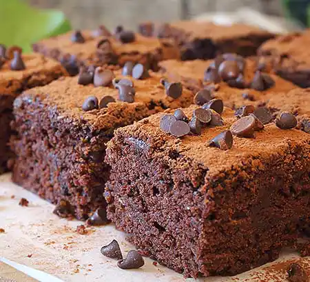 Teller mit Brownies mit Schokochips und Kakaopulvertopping.