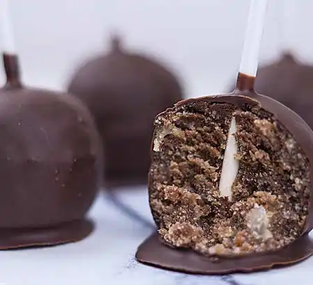 Cake-Pop angeschnitten mit Füllung aus Walnuss, Marzipan und dunkler Schokolade.