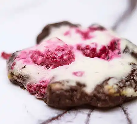Dunkler Cookie mit Himbeeren.