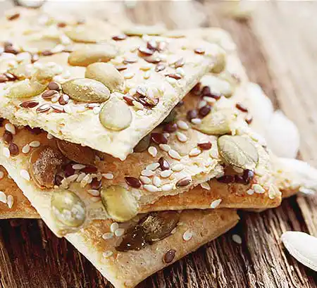 Cookies mit Leinsamen und Sesam auf Holzbrett.