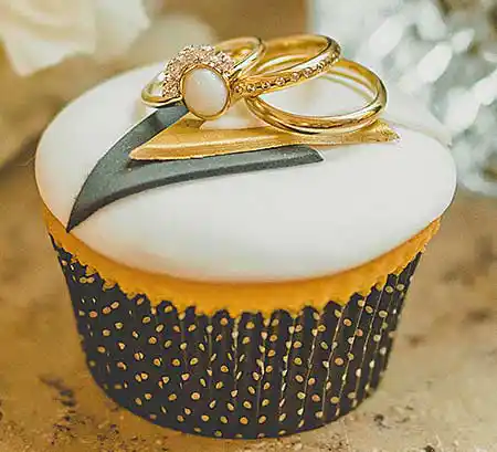 Schönes Cupcake mit weißem Zuckerguß und Eheringen darauf.