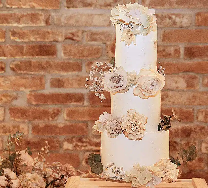 3-stöckige weiße Hochzeitstorte mit Blumendekor.