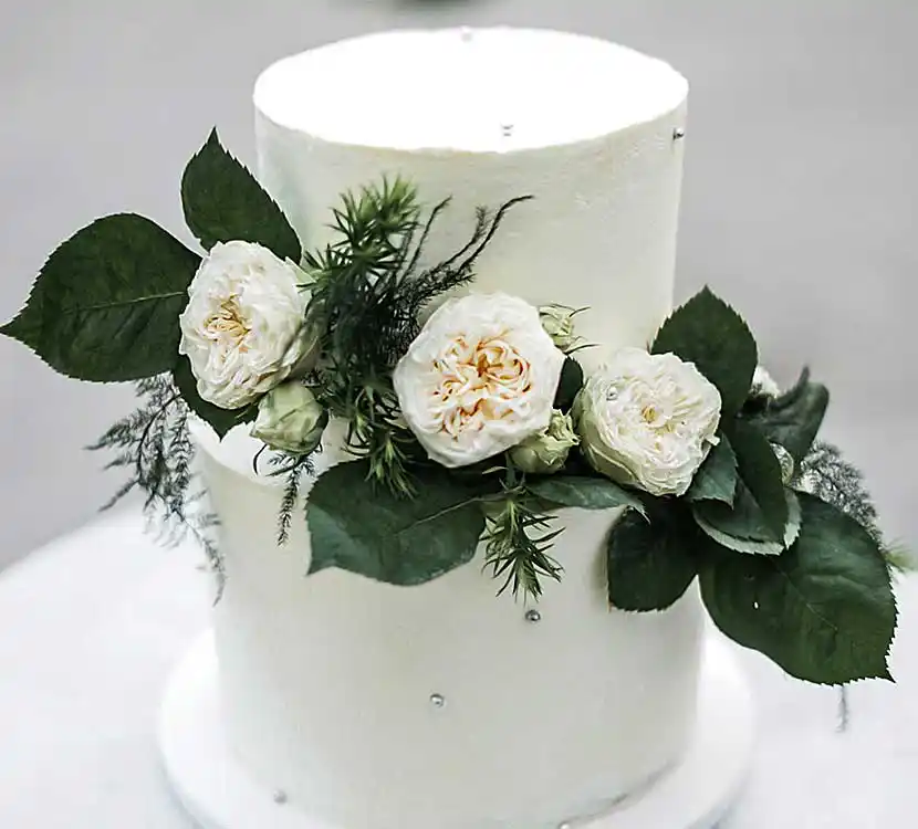 2-stöckige weiße Hochzeitstorte mit Blumendekor.