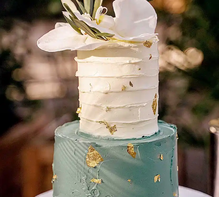 2-stöckige und grün-weiße Hochzeitstorte mit Blumendekor.