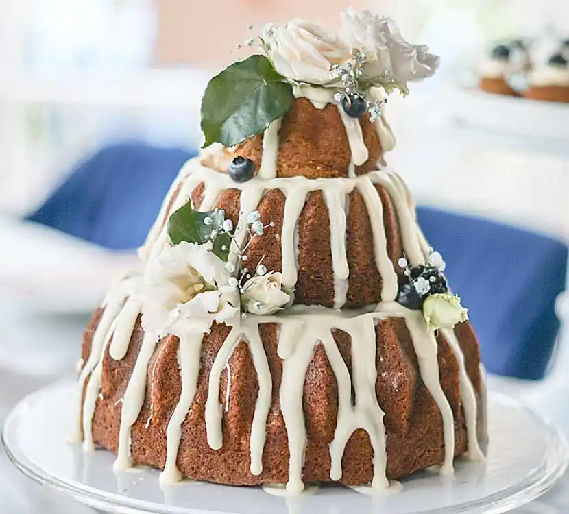 3-stöckige Torte aus Guglhupfkuchen mit Zuckerguss und Blumendekor.