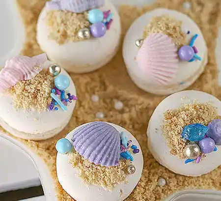 Weiße Macarons mit Muschel-Deko.