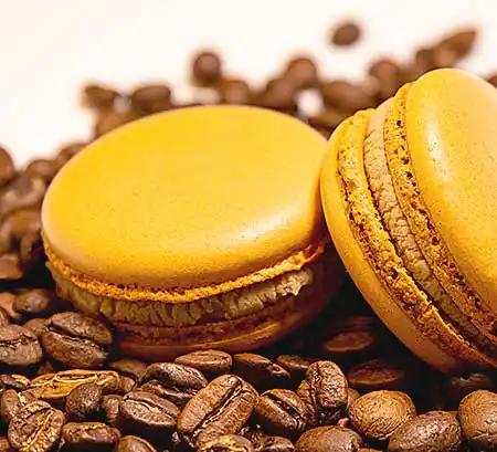 Gelbe Macarons auf Kaffeebohnen.