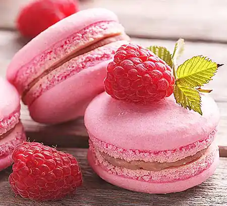 Rosa Macarons mit Himbeeren und Minze.