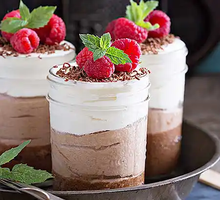 Gläser mit heller und dunkler Schoko-Mousse und Minze.