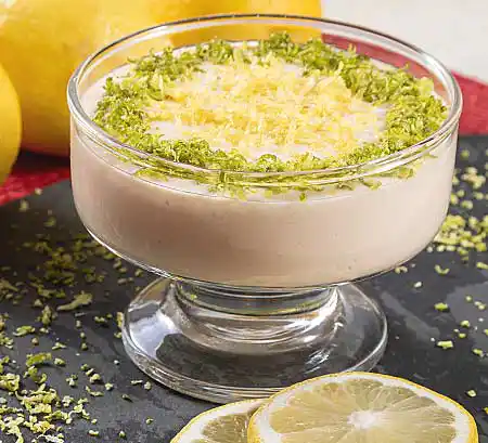 Glas mit Zitronen-Mousse aus einer Mascarpone-Sahne-Crème mit frischem Lemon Curd und echten Zitronen.