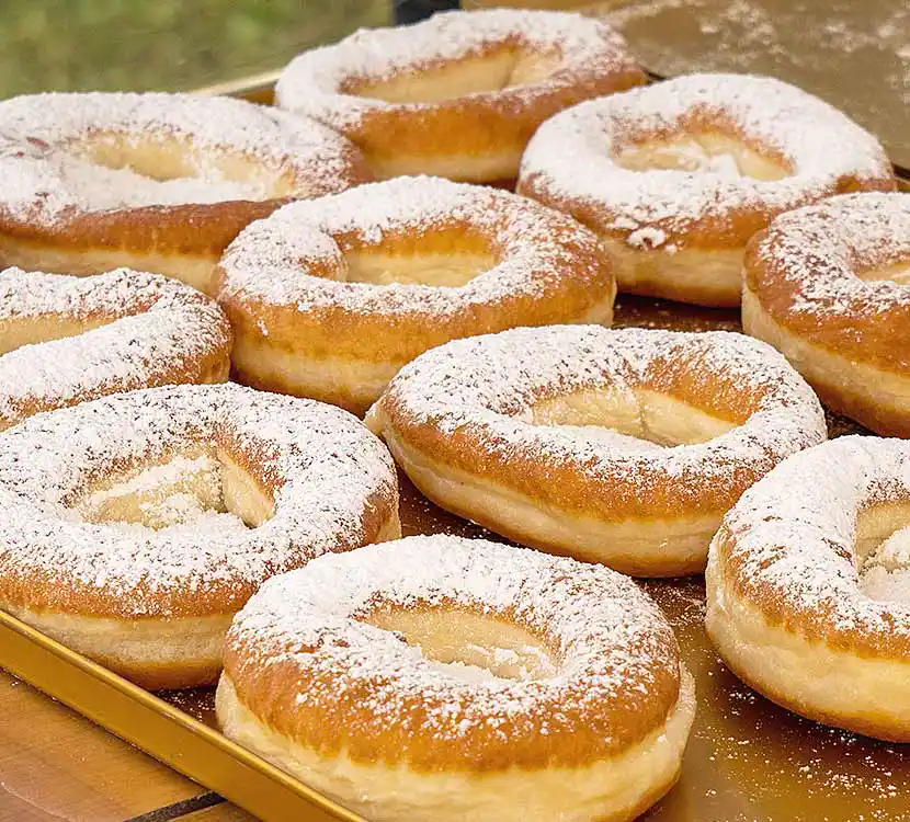 Tablett mit vielen Küchlein und Puderzucker.