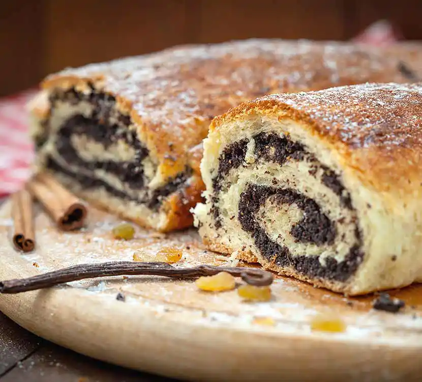 Zwei große Stück Mohnstrudel auf Tablett.