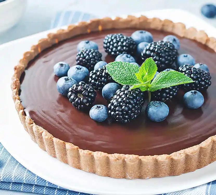 Ganzer Kuchen mit Schokofüllung und blauen Beeren.