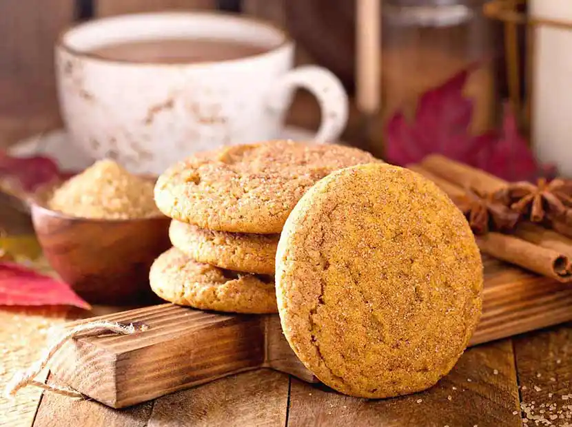 Cookies auf Holztisch mit Teetasse.