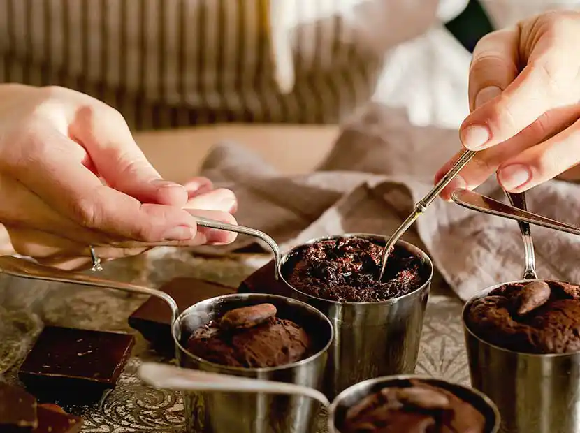 Konditorhände richtet Muffins auf Teller an.