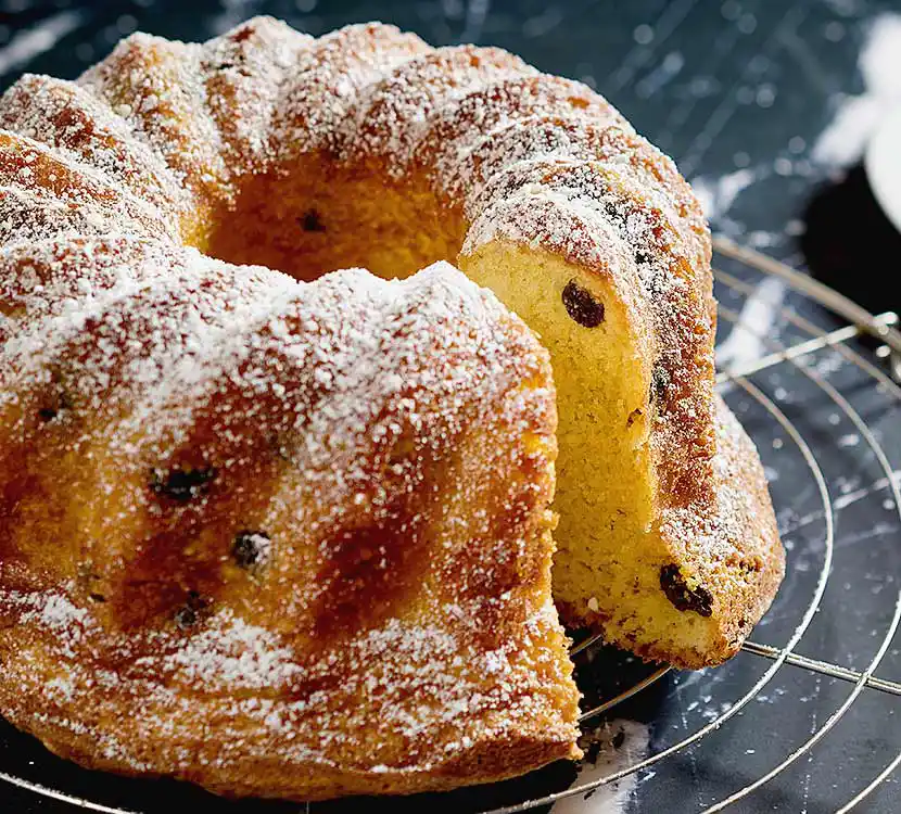 Tisch mit angeschnittenem Cranberry-Guglhupf.