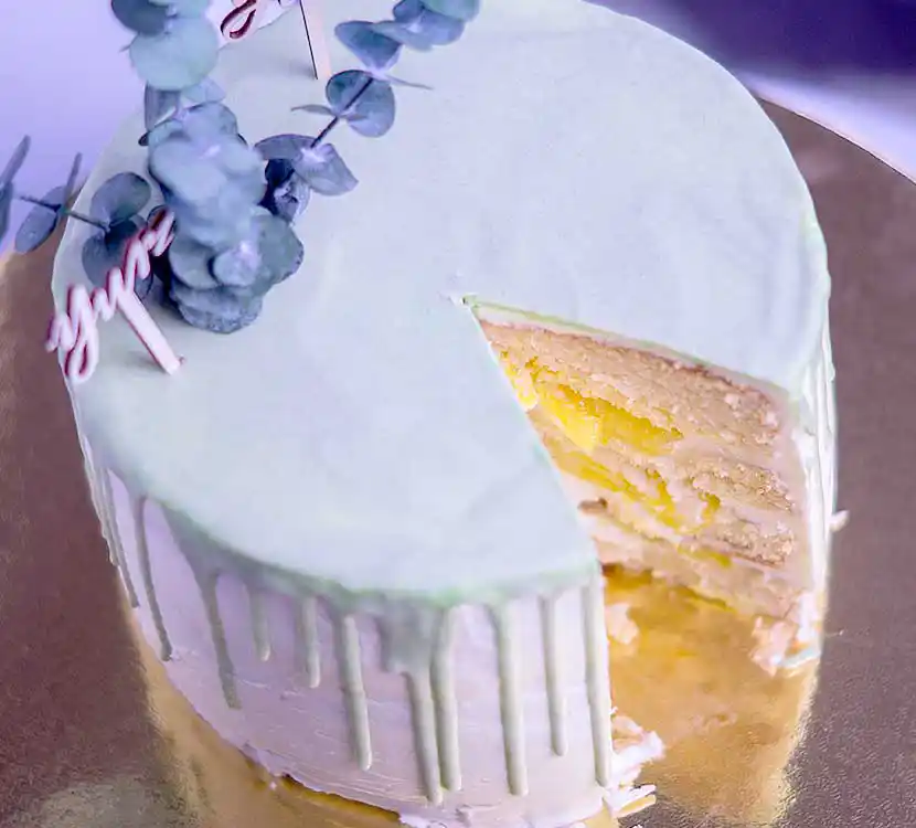 Angeschnittene weiße Torte mit grüner Schoko-Drip.