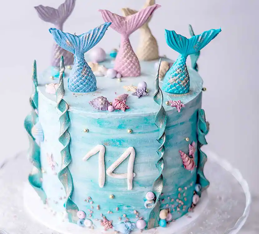 Teller mit blauer Torte und Meerjungfrauen-Deko.