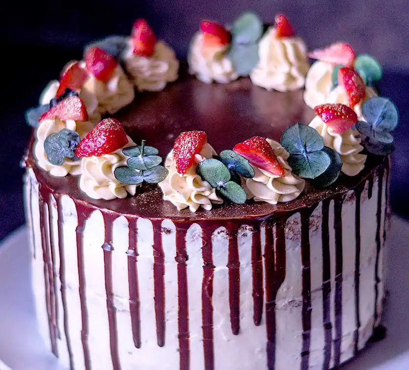 Tolle weiße Torte mit Schok-Drip und Erdbeer-Zucker-Blumendeko.